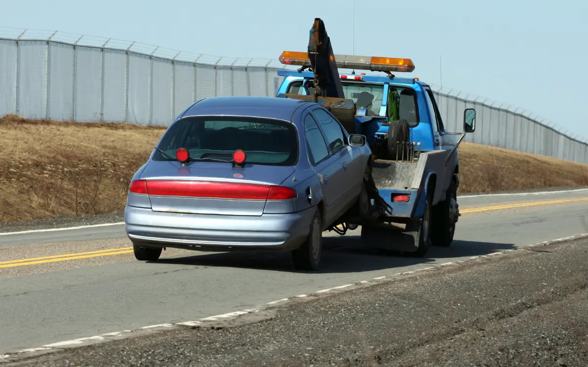 towing truck pulls a car with tow dolly method